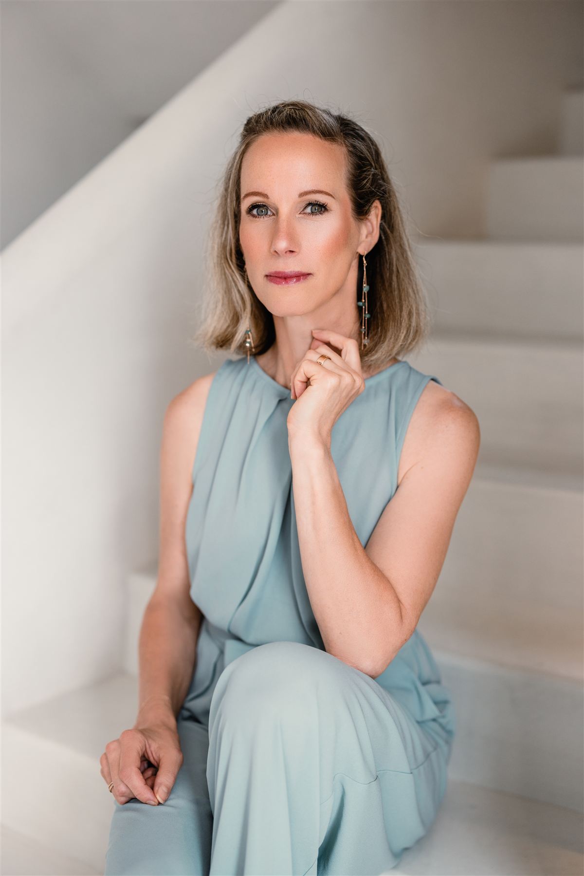 Barbara sitzt auf einer hellen Treppe